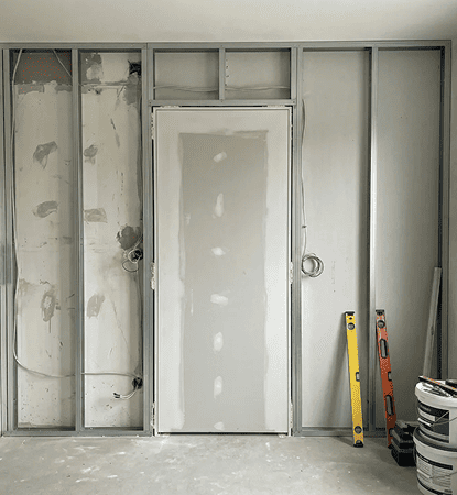 Technician aligning a concealed frame during hidden door installation